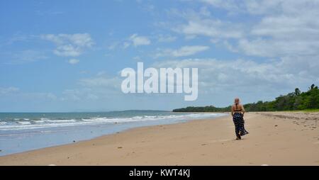 Women walking alone on a remote tropical beach, Balgal Beach, Queensland, Australia Stock Photo