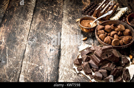 Different types of chocolate, cocoa powder and pieces of dark chocolate. On a wooden background. Stock Photo