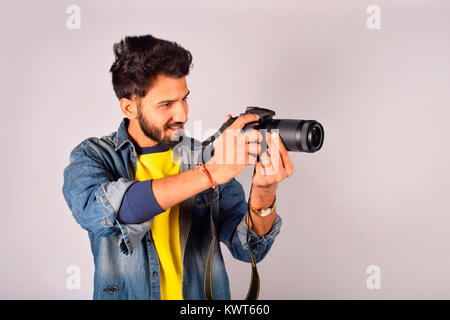 Stylish indian young man photographer wear casual posed outdoor with dslr  photo camera at hands Stock Photo  Alamy