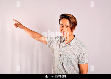 Indian male pointing at something with a happy expression, Pune, Maharashtra Stock Photo