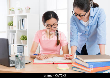 beautiful young lady individual home teacher explaining school textbook content to teach her student studying and preparing exam. Stock Photo