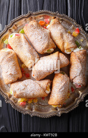 Italian cannoli dessert with a delicate cheese cream close-up on a plate. Vertical top view from above Stock Photo