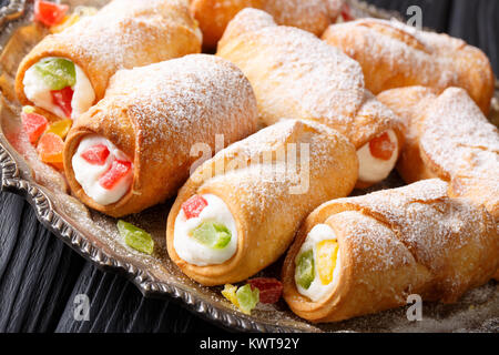 Italian pastries cannoli with cheese cream and candied fruit close-up on a plate. horizontal Stock Photo