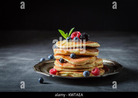 American pancakes with fresh berry fruits on dark table Stock Photo