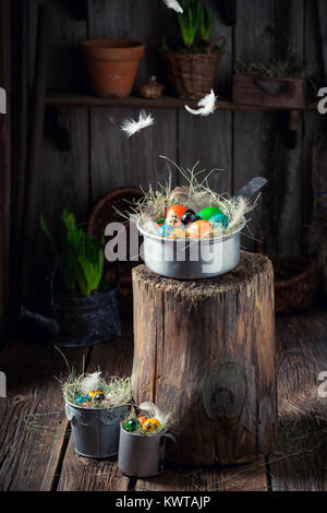 Falling feather on Easter eggs on wooden stump Stock Photo