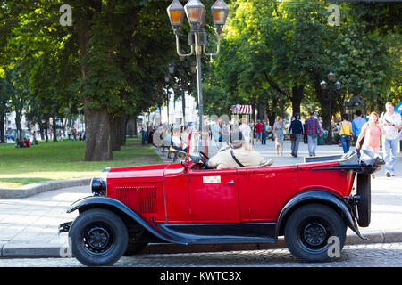 Lviv, Ukraine - July 22, 2017: Old retro Soviet red car GAZ 1936 stands on road. Vintage car cabriolet on city street, side view Stock Photo