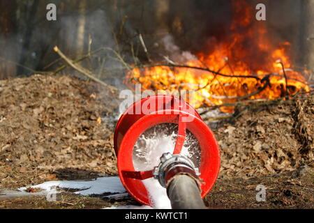 The fireman's hand holds a fire hose to extinguish a fire.Extinguish the fire. Fire hose Stock Photo