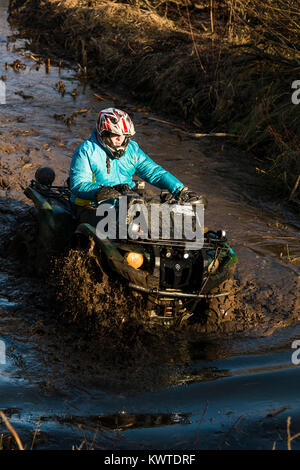 Lviv,Ukraine- December 6, 2015:  Unknown rider on ATV overcomes a water barrier near Lviv, Ukraine Stock Photo