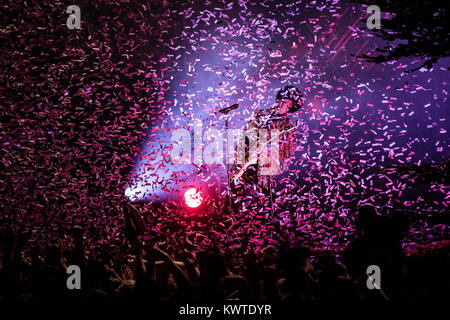 Singer and musician Prince plays a guitar solo while confetti (of course coloured purple) is flying around over the concert crowd at his gig at Skanderborg Festival. Denmark 2013. Stock Photo