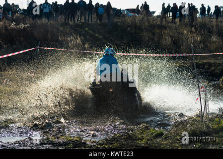 Lviv,Ukraine- December 6, 2015:  Unknown rider on ATV overcomes a water barrier near Lviv, Ukraine Stock Photo