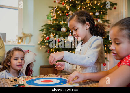 Little girls are playing board games in their home at christmas time. Stock Photo