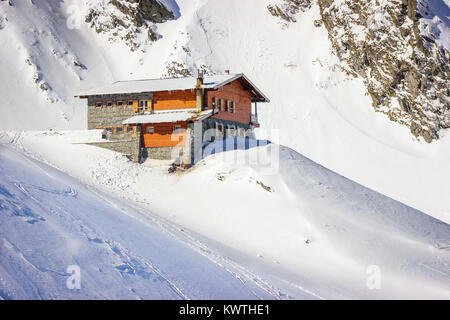 Alpine winter landscape with cabin at Balea Lake and Fagaras Mountains covered with snow in Sibiu County, Romania Stock Photo
