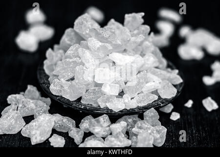Rock sugar or sugar cubes in a glass plate on wooden surface. Stock Photo