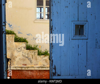 colorful building with a wooden door, brick wall and concrete stairs. Stock Photo