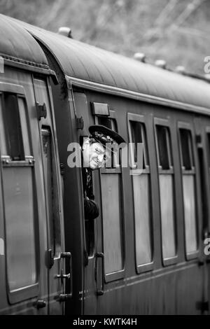 Severn Valley Railway steam locomotive stops for passengers at Alveley's Country Park Halt. Guard looks out of carriage window to check the platform. Stock Photo