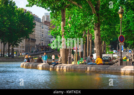 Paris spring, view of young people relaxing on a late spring evening along the embankment of the Canal Saint-Martin in central Paris, France. Stock Photo