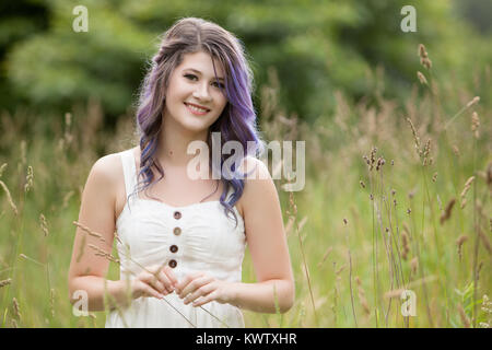 Young Woman with Brunette and Purple Hair in a green park Stock Photo