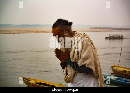 Indian male pilgrim praying to the mother Ganges river in a Hindu traditional manner, Varanasi India Stock Photo