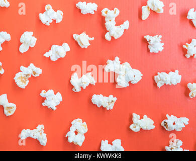 Salted popcorn on the orange paper cardboard from the bucket. Stock Photo