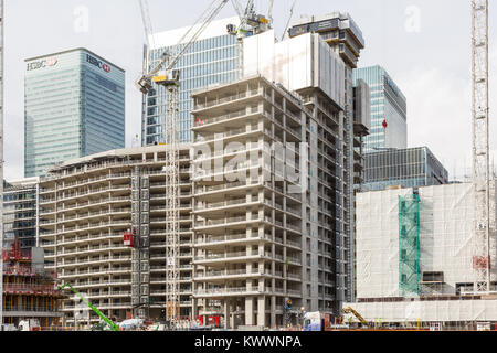 Construction workers and crane at work buildi construction site in London Docklands area at Canary Wharf Stock Photo