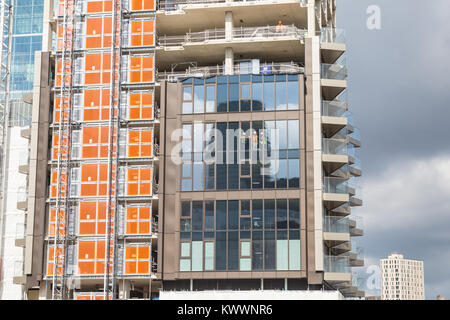 Construction workers and crane at work buildi construction site in London Docklands area at Canary Wharf Stock Photo