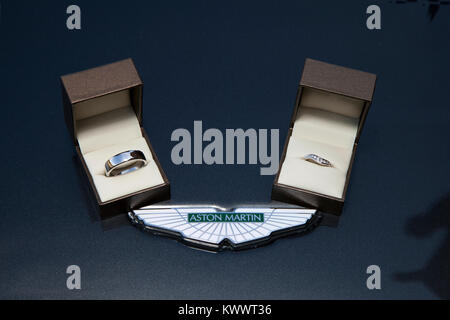 Bride & Groom's wedding rings resting on Aston Martin bonet before wedding. Stock Photo