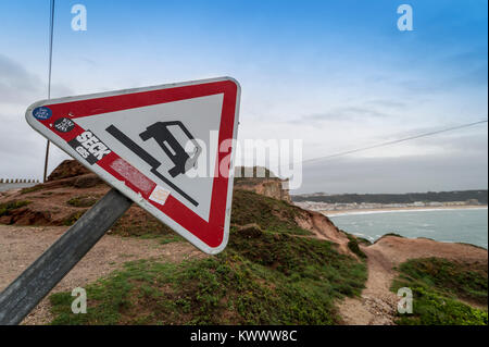 Uneven road with warning sign, on top of cliffs at Nazare, Portugal Stock Photo