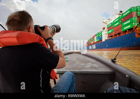 Tourist taking pictures of a container ship passing through the Panama Canal, Republic of Panama. Stock Photo