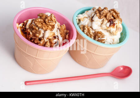 Panna cotta ice cream decorated with walnuts in a delicious plastic bowl. white background. Stock Photo