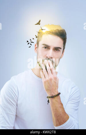 Handsome pleasant man touching his lips Stock Photo
