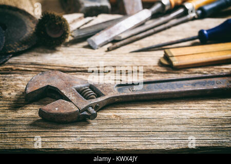 Old used wrench on a wooden surface Stock Photo