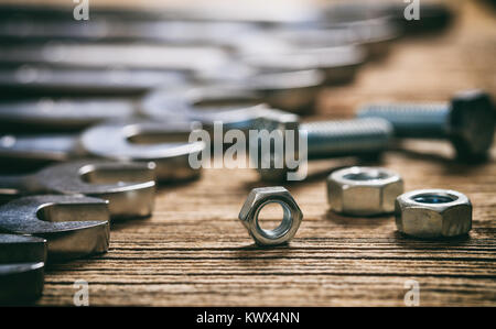 Set of wrenches bolts and nuts on a wooden surface Stock Photo