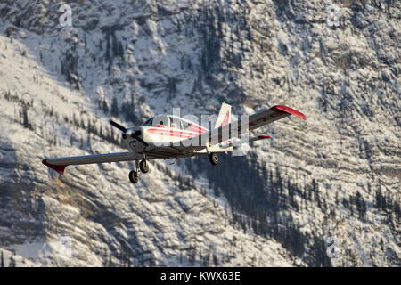 A light airplane flying through the mountains in Jasper National Park in Alberta Canada. Stock Photo