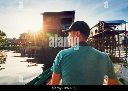 Young man (traveler) in the floating village on the Tonle Sap lake. Siem Reap Province in Cambodia. Stock Photo