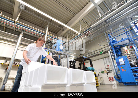 woman works in the shipping department of a company and packs styrofoam components into packages for the customer. Stock Photo