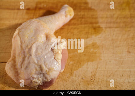 raw chicken leg and thigh on a wood butcher block Stock Photo