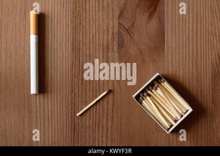 One cigarette near match and matchbox on wooden background Stock Photo