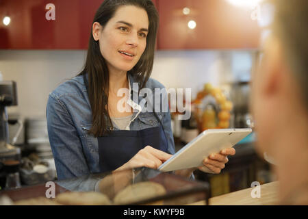 Waitress in coffee shop taking order on digital tablet Stock Photo