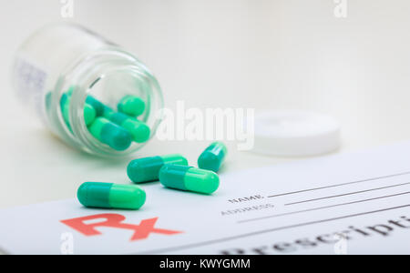 Capsules out of a bottle on white background Stock Photo