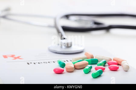 Pills and a stethoscope on a blank prescription on white background Stock Photo