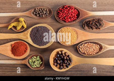 Variety of colorful spices, wooden surface Stock Photo