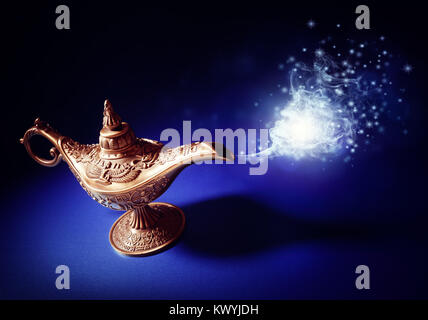 Magic lamp from the story of Aladdin with Genie appearing in blue smoke concept for wishing, luck and magic Stock Photo
