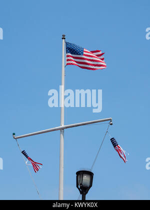 The American flag is flying on top of a flagpole at the port city of Monterey, California Stock Photo