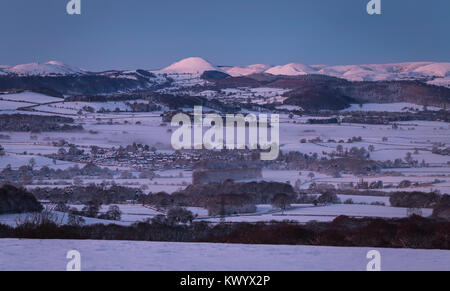 Shropshire Hills covered in in snow and morning mists over winter land at dawn Stock Photo