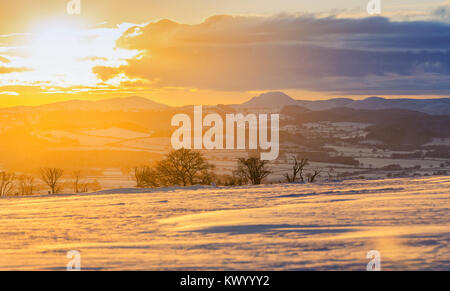 Setting Sun over scenic hills covered in snow. Shropshire Hills in United Kingdom Stock Photo