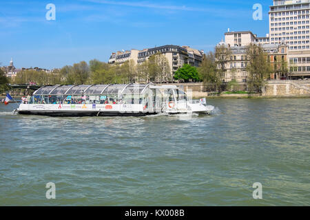 PARIS, FRANCE - APRIL 20 2016: Passenger boat passes Ile Saint-Louis on river Seine in central Paris Stock Photo