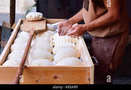 Unrecognizable baker sprinkle bread dough with flour Stock Photo