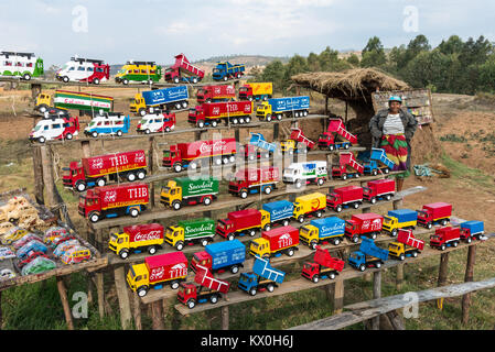 Colorful toy cars and trucks are for sell on road side stand. Madagascar, Africa. Stock Photo