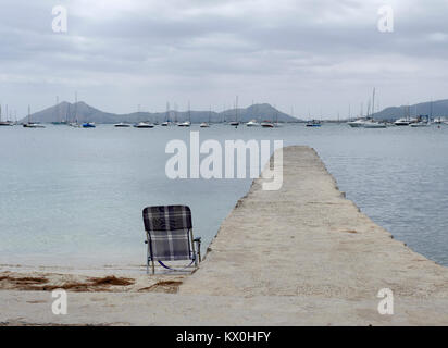 Concrete pier and chair. Port de Pollenca. Mallorca. Spain Stock Photo