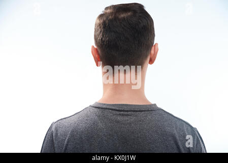 Man in gray shirt back view close-up isolated on white background. Stock Photo